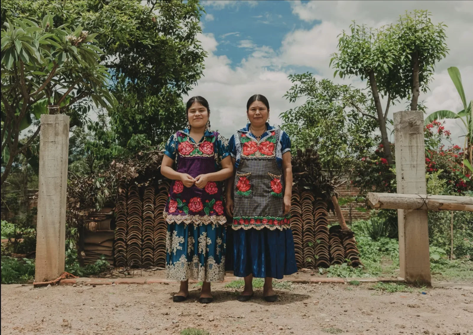 Two artisans in traditional embroidered dress outside their workshop, Santa Maria Atzompa, Oaxaca
